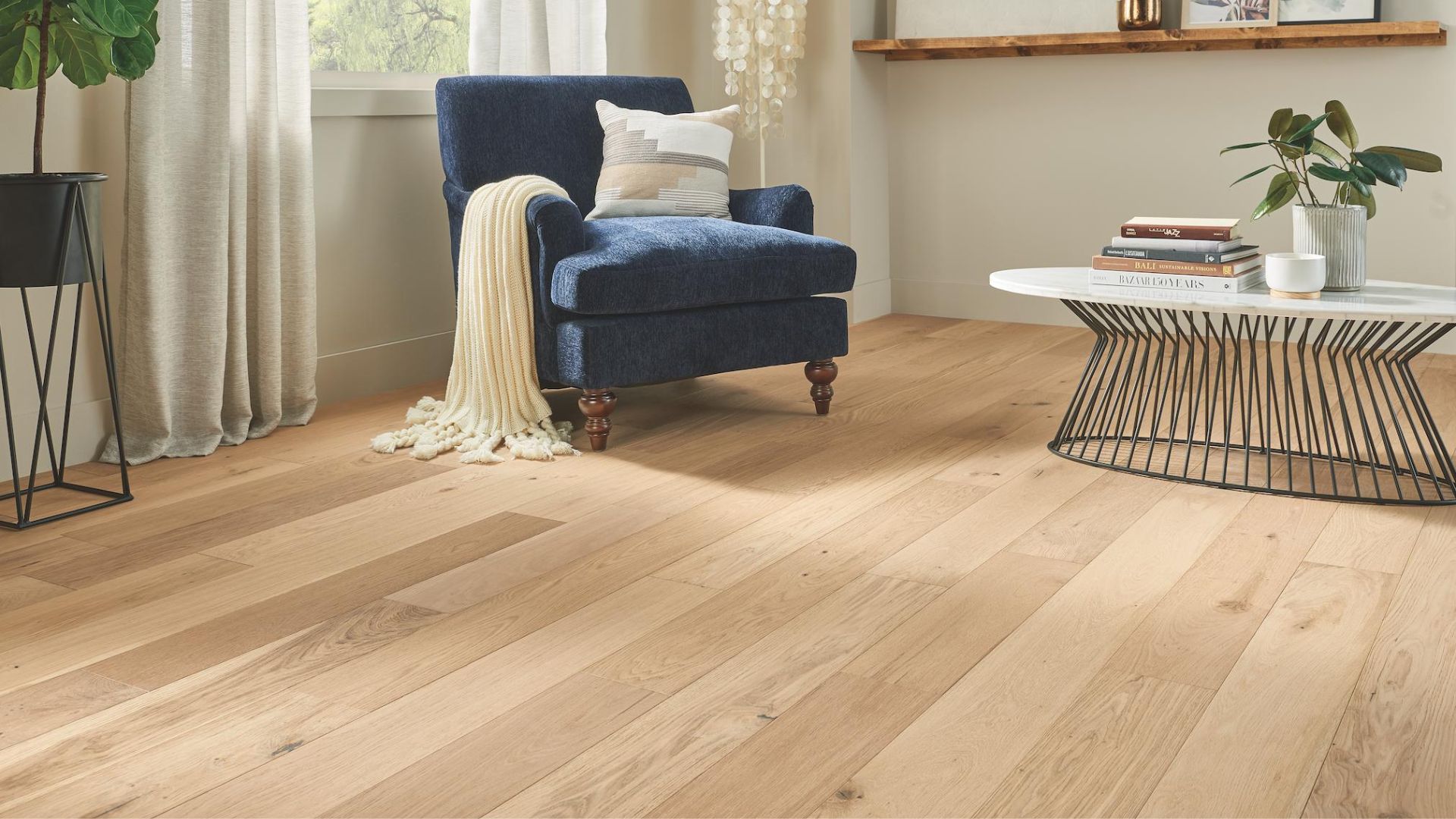 bright hardwood flooring in a cozy living room with blue chair and coffee table